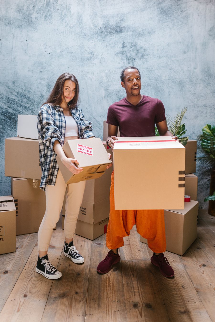 Movers carrying packed cartons into a new flat