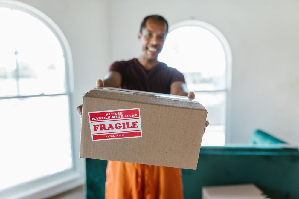 A carton marked fragile being handled carefully